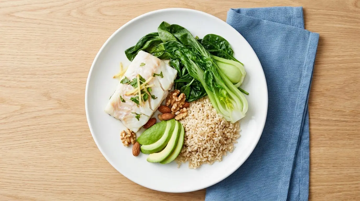 Heart-healthy Malaysian meal u2014 steamed fish, greens, brown rice and nuts, arranged by a dietitian for cholesterol management