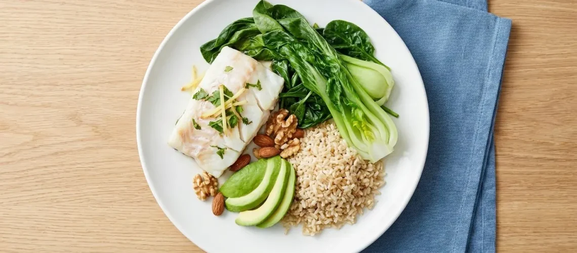 Heart-healthy Malaysian meal u2014 steamed fish, greens, brown rice and nuts, arranged by a dietitian for cholesterol management